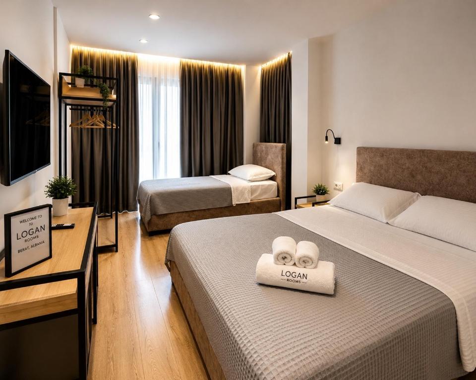 a hotel room with two beds with towels on the bed at Logan Rooms Berat in Berat