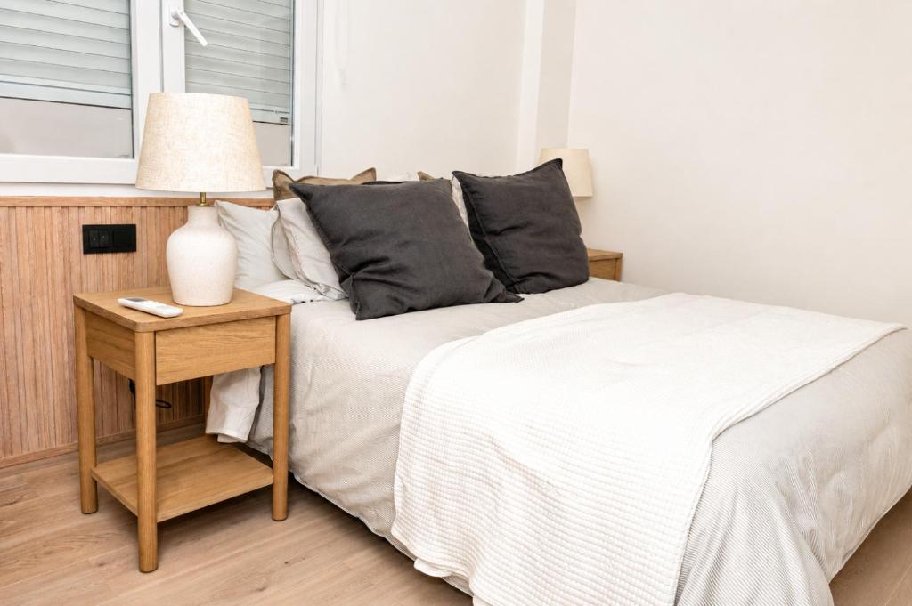 a bedroom with a bed and a table with a lamp at Carvajal Street, Private rooms in Madrid