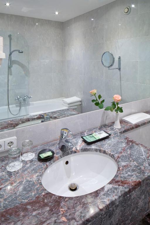 a bathroom with a sink and a shower and a counter at Hotel Penz West in Innsbruck