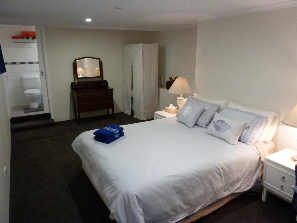 a bedroom with a large white bed and a mirror at Panorama on Sorell B&B in Sorell