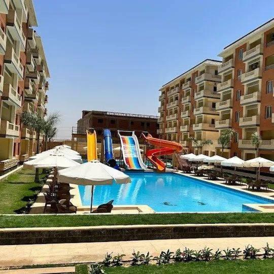 a swimming pool with a slide and a water park at New Coast Chalets -K77 in Dawwār Muḩammad Abū Shunaynah