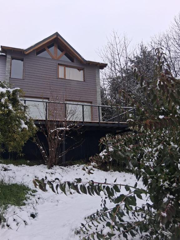 a house with a deck in the snow at Casa Tinta in San Carlos de Bariloche