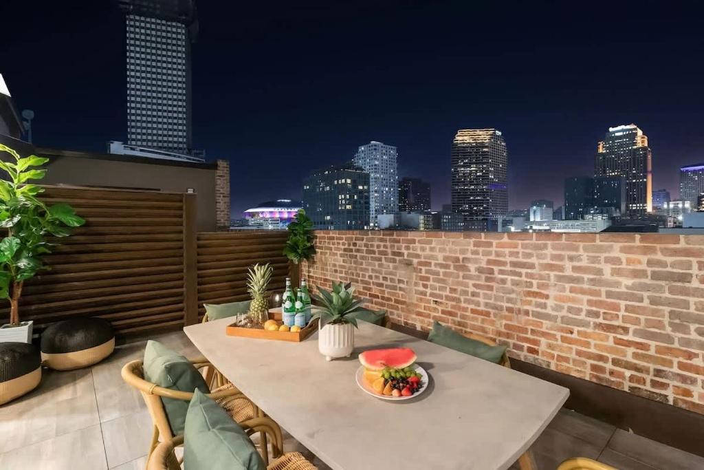 a table on a rooftop with a view of the city at LUX Suite Rooftop Pool Workspace Games Hotel in New Orleans