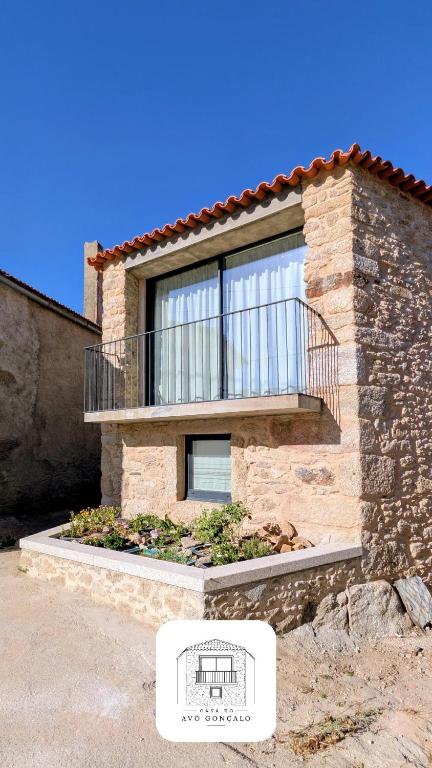 a building with a balcony on the side of it at Casa do Avô Gonçalo in Mogadouro