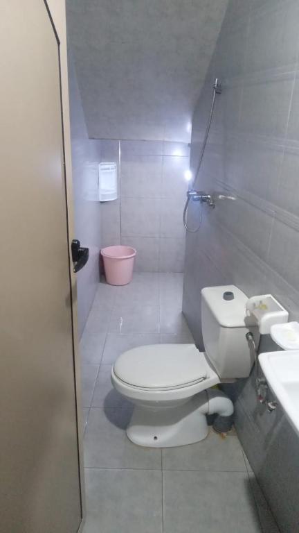 a white bathroom with a toilet and a sink at Tamawanza in Aourir