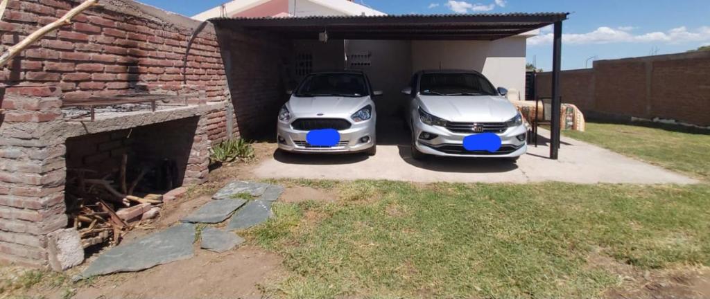 two white cars are parked in a garage at Casa en La Punta in La Punta