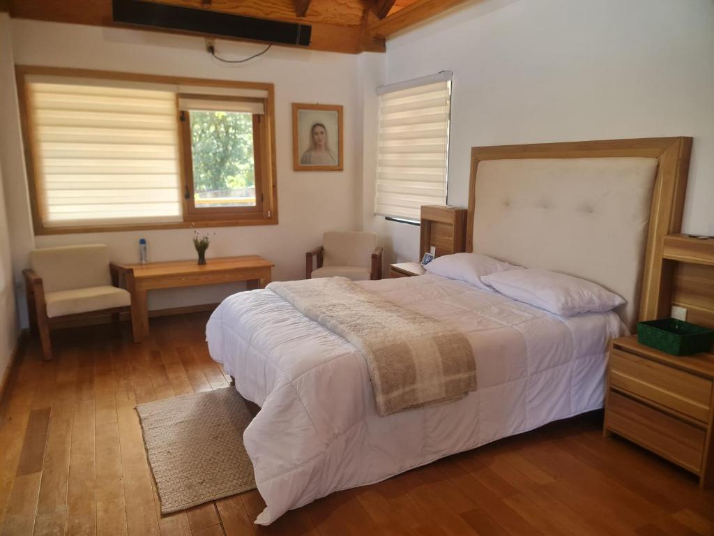 a bedroom with a bed and a table and chairs at Cabaña Baño de bosque in Coscotitlán