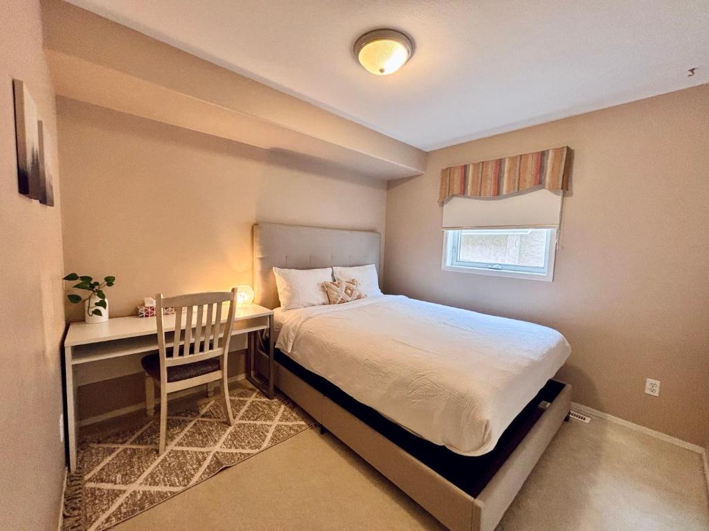 a bedroom with a bed and a desk with a chair at Saskatoon Lashyn Cove Homestay in Saskatoon