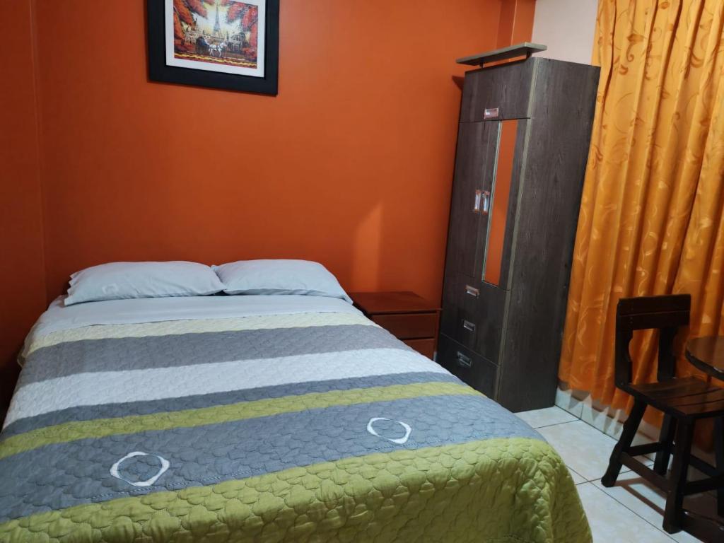 a bedroom with a bed and a black dresser at Hostal paris in Nazca