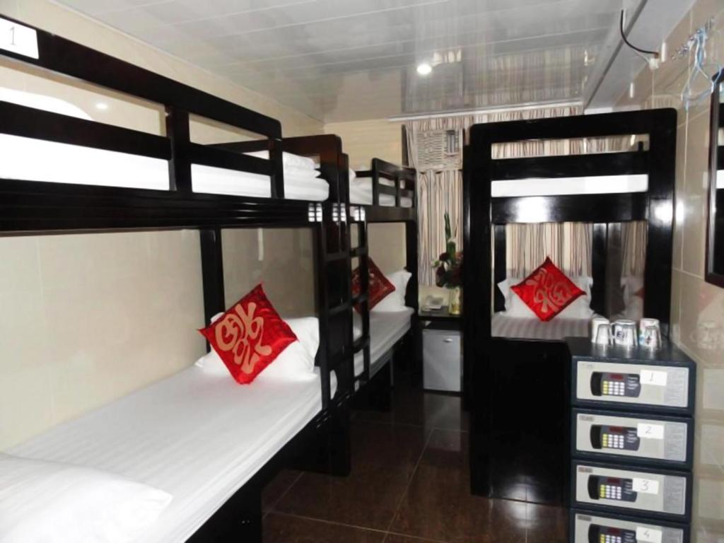 a room with three bunk beds with red pillows at Paris Guest House (D2, 10/F) in Hong Kong