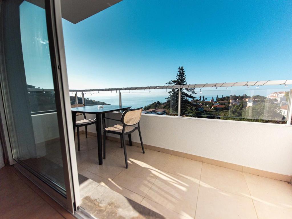 ein Balkon mit Tisch und Meerblick in der Unterkunft Sunflower Ocean View Apartment With Pool & Parking in Caniço