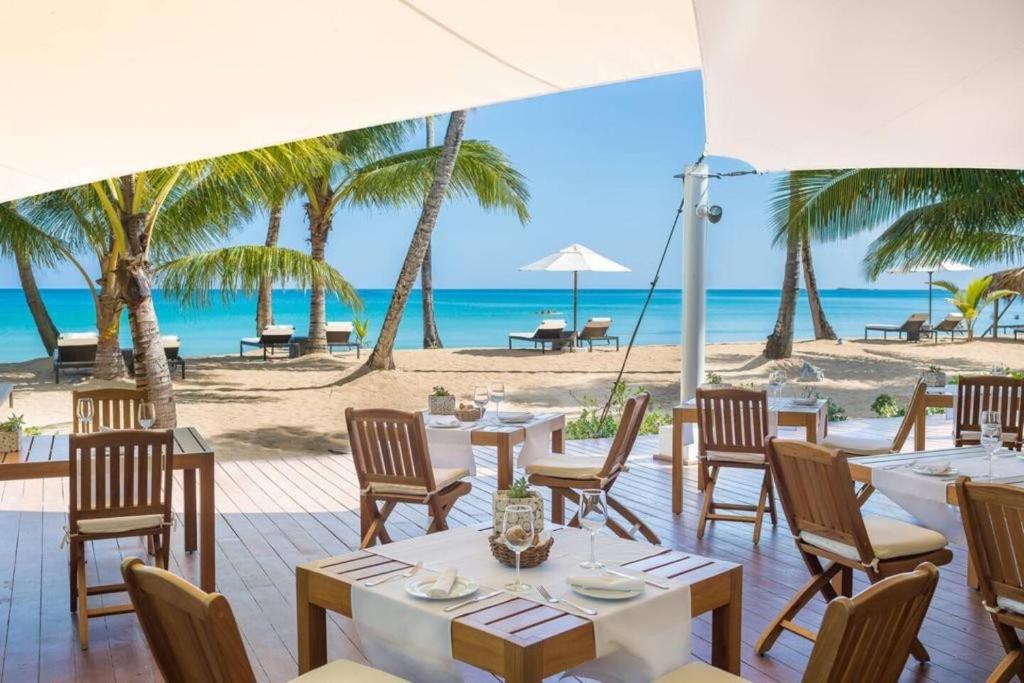 a restaurant on the beach with tables and chairs at Sublimeluxcondo Terrenas Jaccuzibeachfront in Las Terrenas