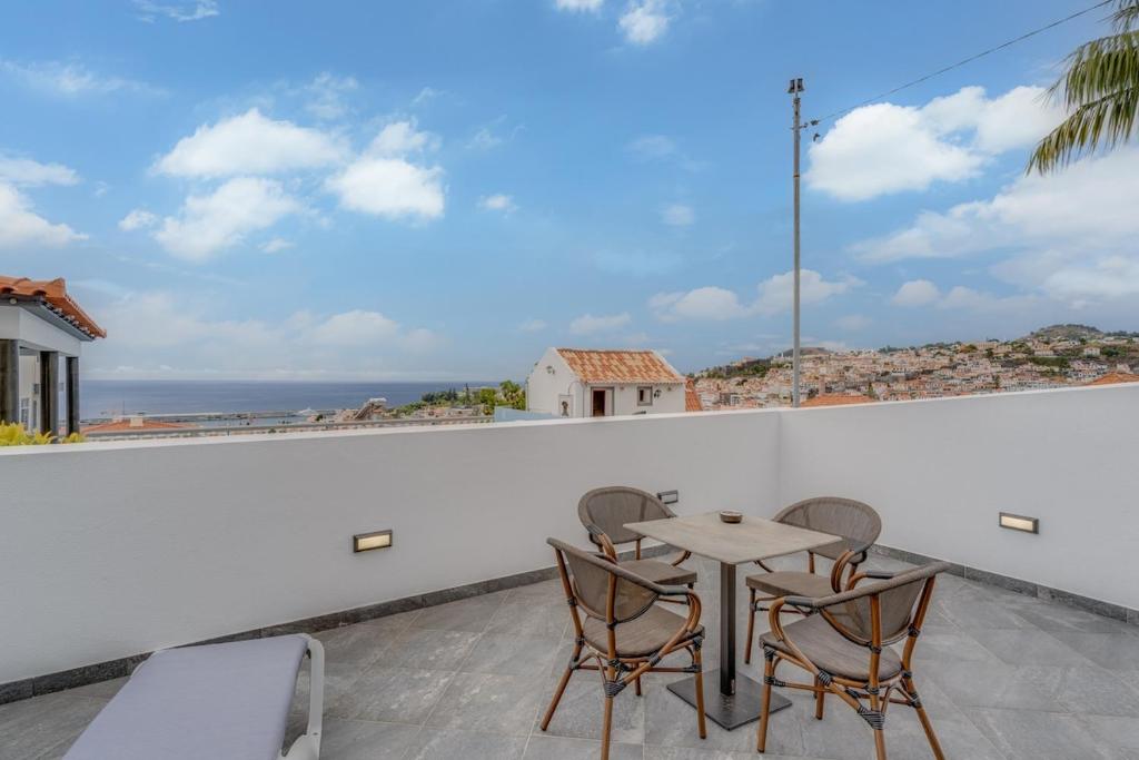 a table and chairs on a balcony with a view of the ocean at Villa Winter Apt 1 in Funchal
