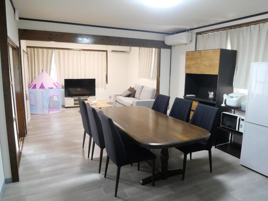 a living room with a dining room table and chairs at ASO Uchinomaki Stay in Aso