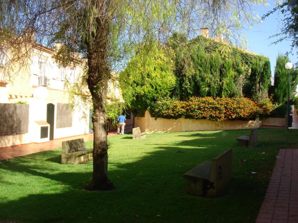 un parque con bancos y un árbol en el césped en Chalet Pto Sta Maria, SOLO FAMILIAS, en El Puerto de Santa María