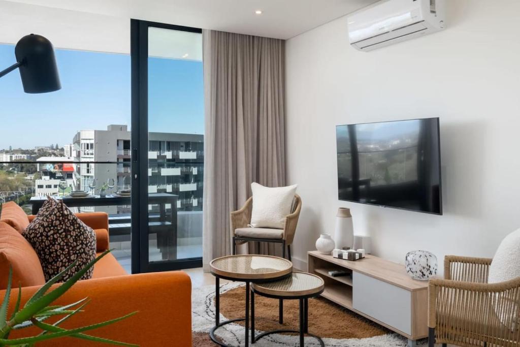 a living room with a couch and a tv at Newlands Peak Luxury Suite in Cape Town