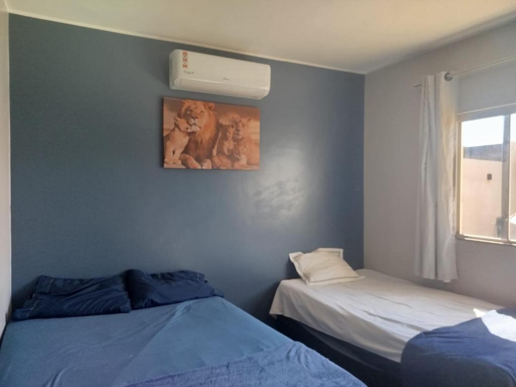 a bedroom with two beds and a picture on the wall at Casa com Ar-Condicionado in Formosa