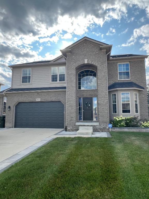 a large brick house with a garage at Sterling Heights Retreat ! in Sterling Heights