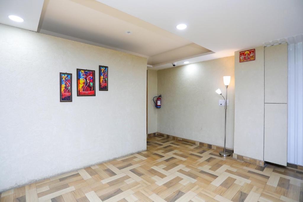 a room with paintings on the wall and a wooden floor at Hotel O The Signature inn in Indirapuram