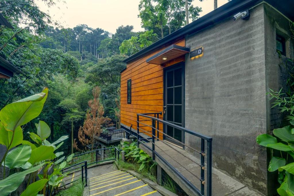 a house with a staircase leading up to the door at Mariposa Cabin in Lembang