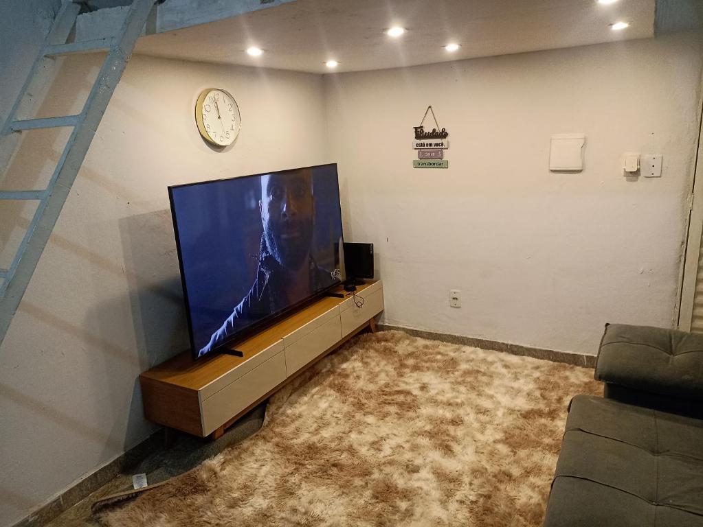 a living room with a large flat screen tv at Estúdio 800m do Buriti Shopping in Aparecida de Goiânia