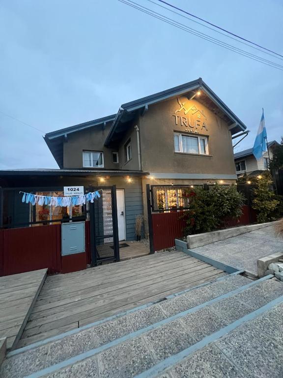 a house with a staircase leading to a building at Hostel TRUFA in San Carlos de Bariloche