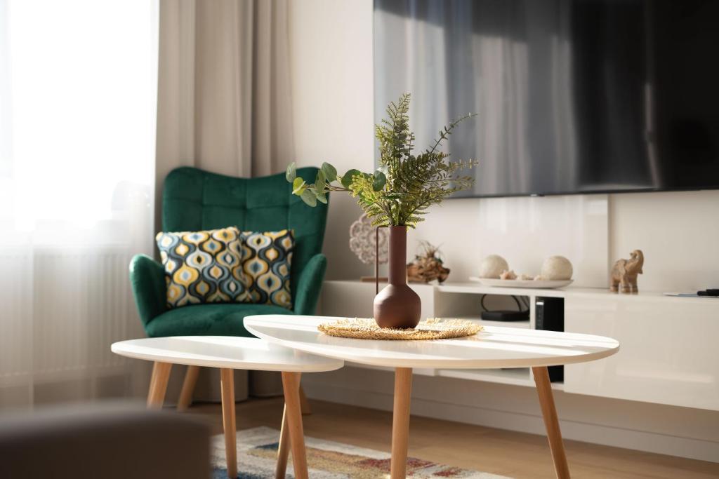 a living room with a table and a green chair at NOVERA Apartments #24 in Turčianske Teplice