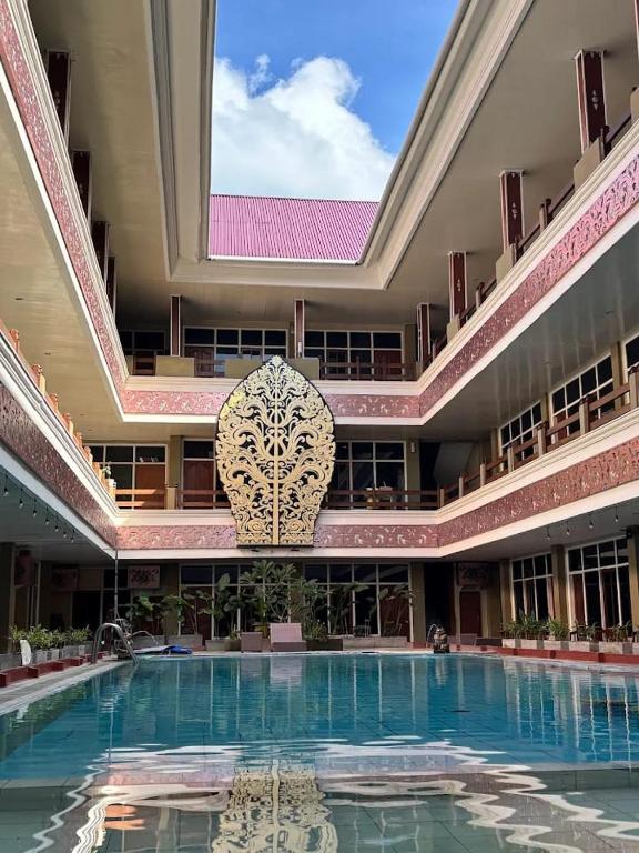 a large swimming pool in a large building at Hotel Karthi Kuta in Kuta