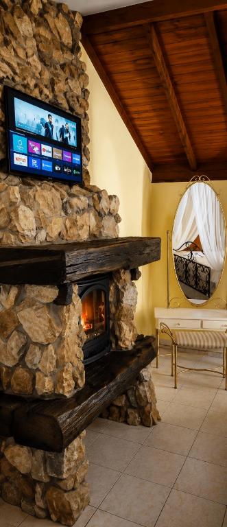 a stone fireplace with a television on top of it at HOTEL VELHA CORTE VW-AUDI Sjp in São José dos Pinhais