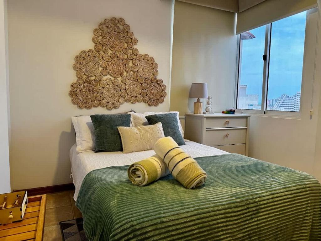 a bedroom with a bed with a green blanket at Remodeled Margarita Apt Pool in Porlamar