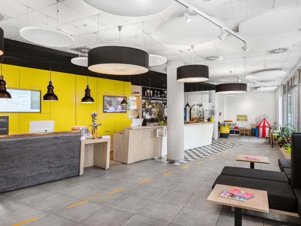 a restaurant with yellow walls and a counter in a room at Ibis Styles Budapest City in Budapest