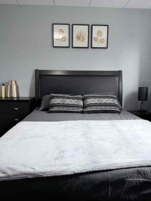 a bedroom with a large bed with two pictures on the wall at 2806 Regina in Regina