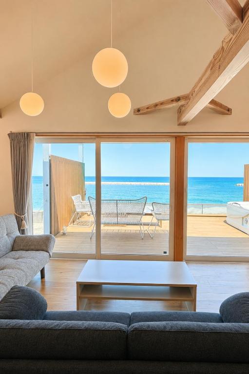 a living room with a view of the ocean at Beach SPA TSUDA 0 Cero棟 in Sanuki