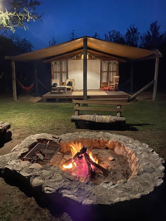 a fire pit in front of a house at Glamping Traslasierra Carpa Sur in San Javier