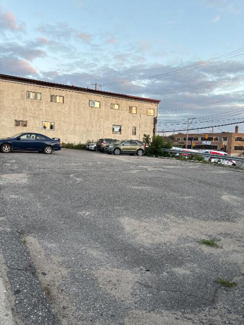 a parking lot with cars parked in front of a building at Cozy Home in Flin Flon