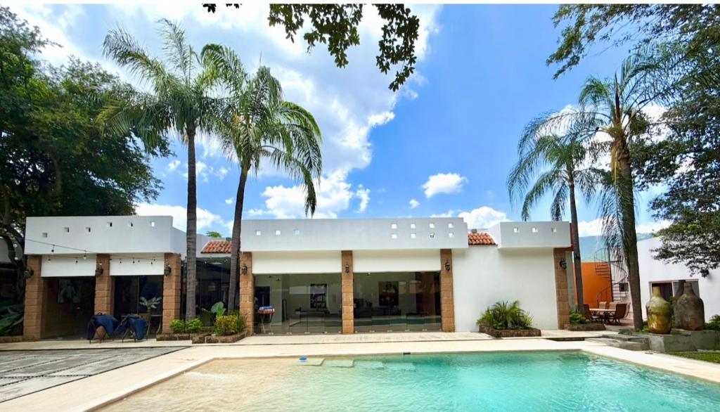 a house with a swimming pool and palm trees at Quinta Encanto in Santiago Nuevo León in Santiago