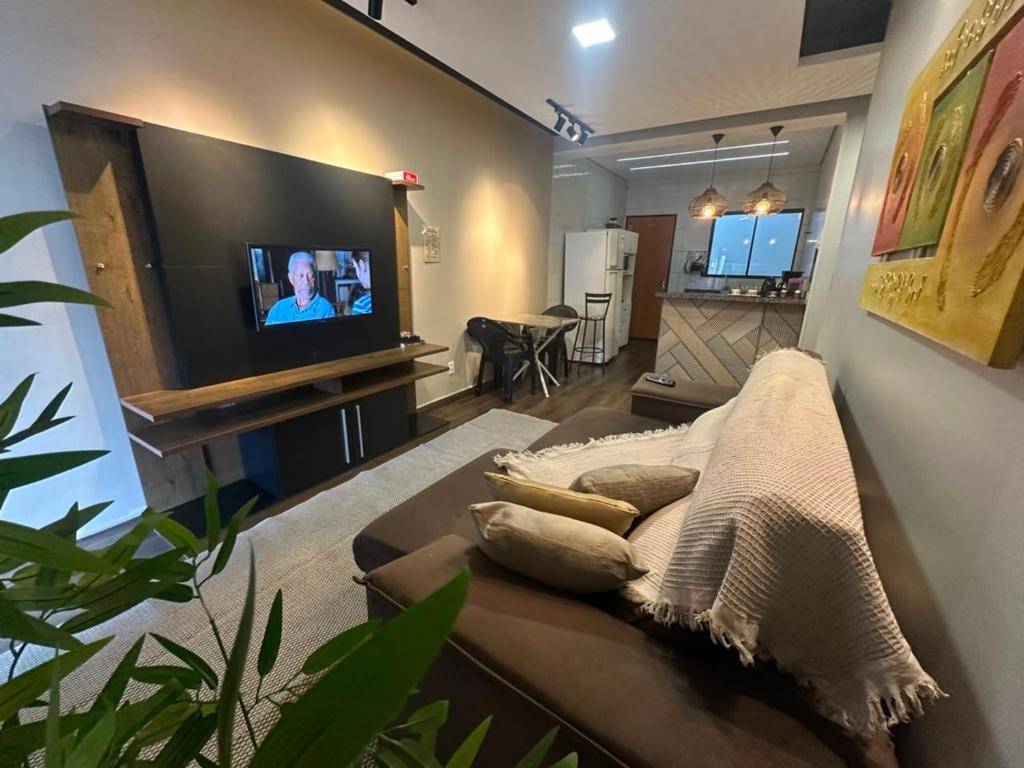 a living room with a couch and a flat screen tv at Conforto - Casa completa com ar-cond - Wi-Fi in Trindade