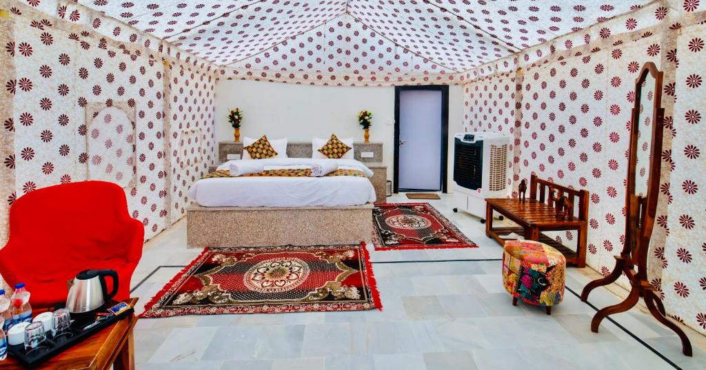 a bedroom with a bed and a tv in it at Jaisalmer Sand Dunes Resort in Jaisalmer