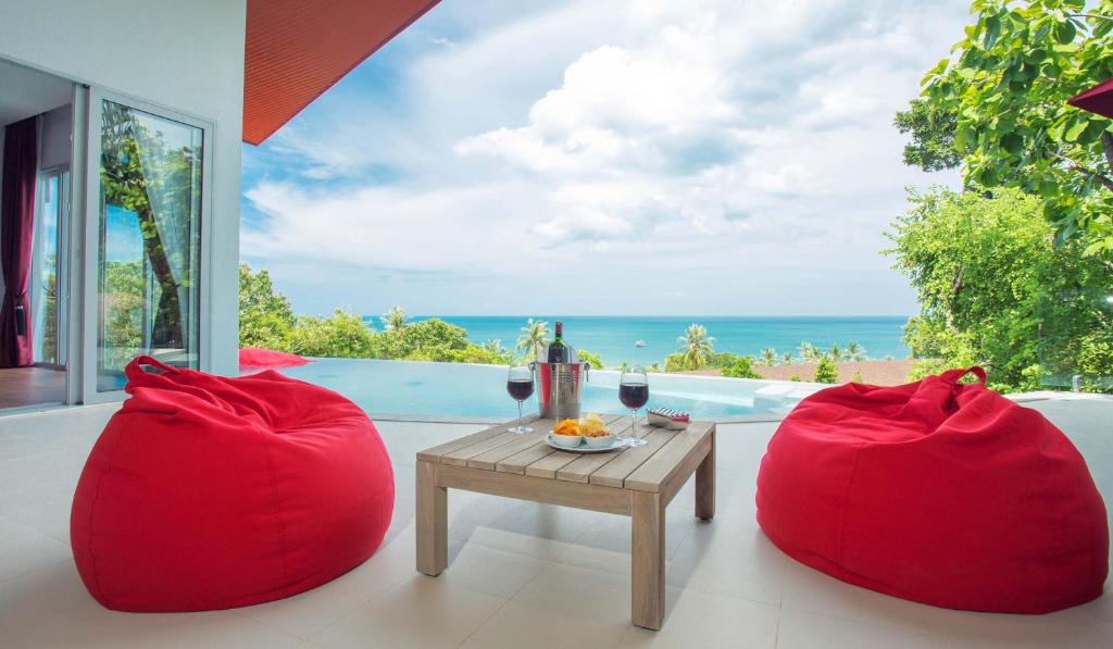 a room with two red bean chairs and a table at Eranda Pool Spa Villa, Chaweng Koh Samui in Chaweng