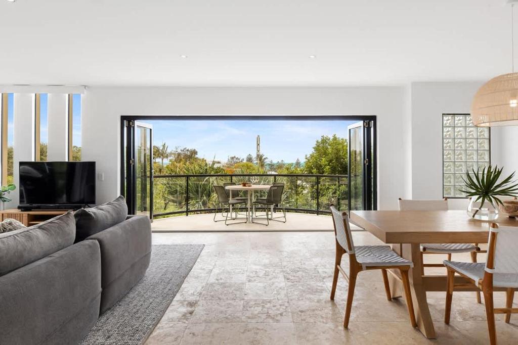 a living room with a couch and a table at Beach Luxury, Ocean Views & Pool in Noosa Heads