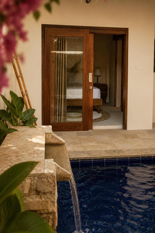 a room with a swimming pool and a bedroom at Seraya Villas in Kuta Lombok