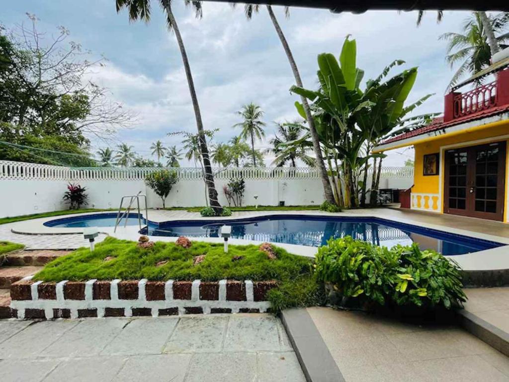a swimming pool in front of a house at Nina's Aqua - Private Pool Villa & Plunge Pool Studios, Anjuna in Anjuna