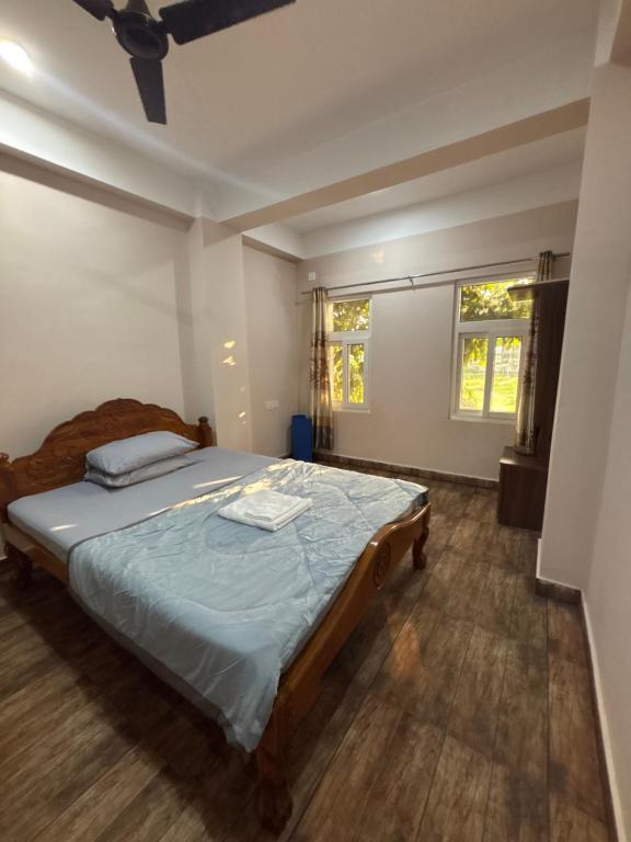 a bedroom with a bed and two windows at Haven Stay in Panchanai