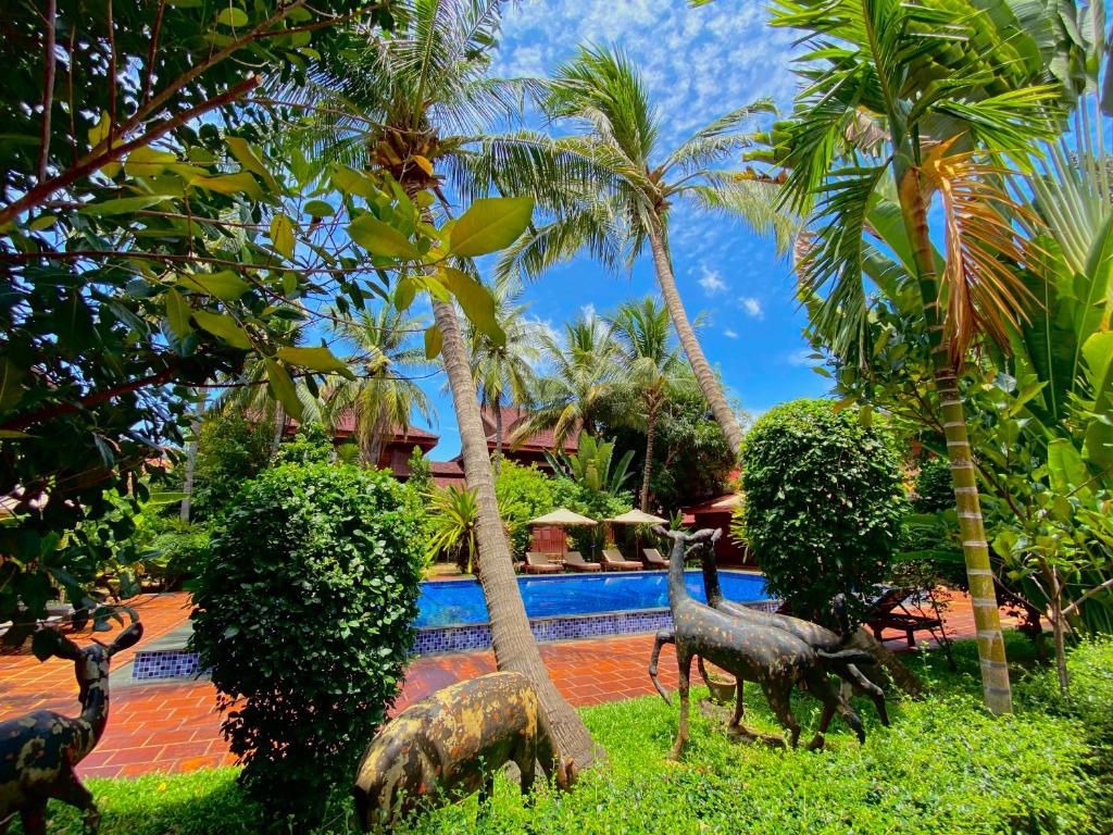 a statue of dinosaurs in the yard of a resort at ASANA Villas in Siem Reap