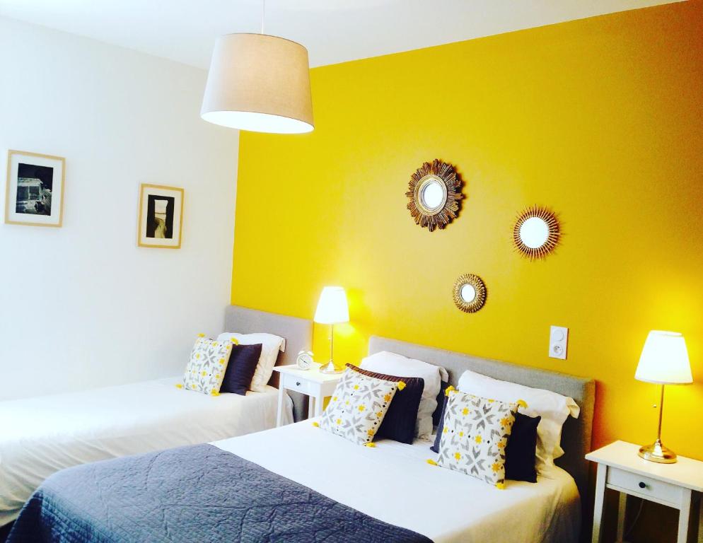 a bedroom with two beds and a yellow wall at Hotel Saint-Michel in Dinard