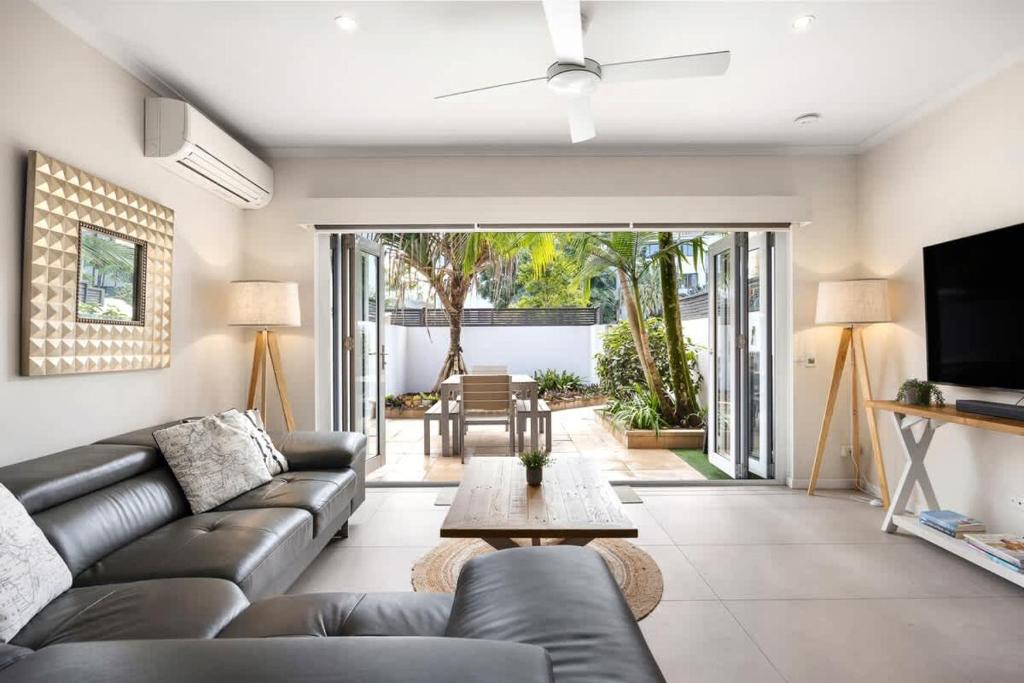 a living room with a couch and a table at Moondarah: Pet-Friendly Escape in Noosa Heads