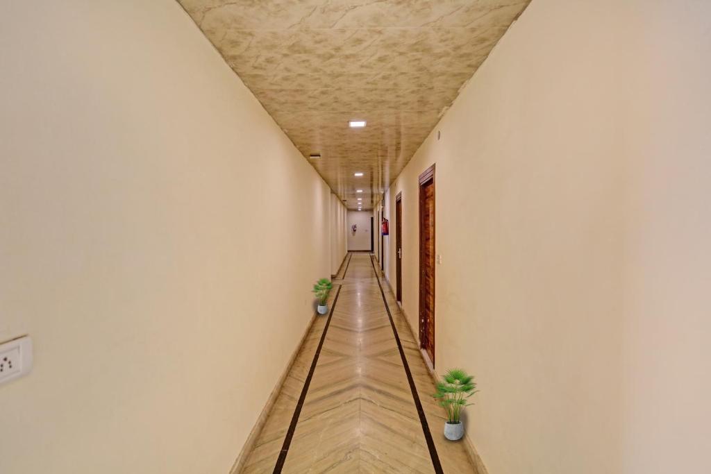 a corridor of a building with two potted plants at Hotel O Raas Near Hira Sweet in New Delhi