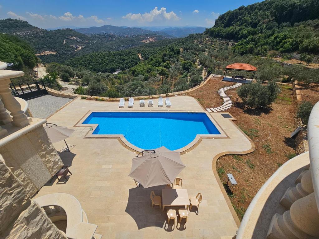 an overhead view of a swimming pool with umbrellas at Moufid villa in Al Mīdān
