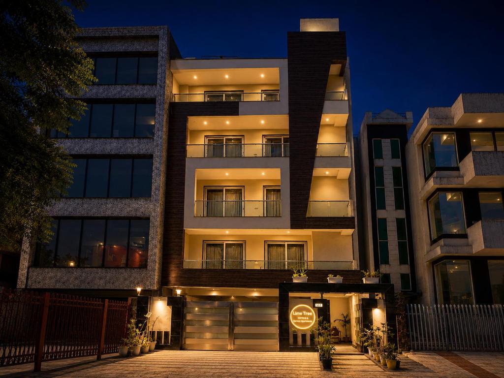 an apartment building at night with a sign on it at Lime Tree Hotel Golf Course Extension Nearby Grand Hyatt Gurgaon in Gurgaon
