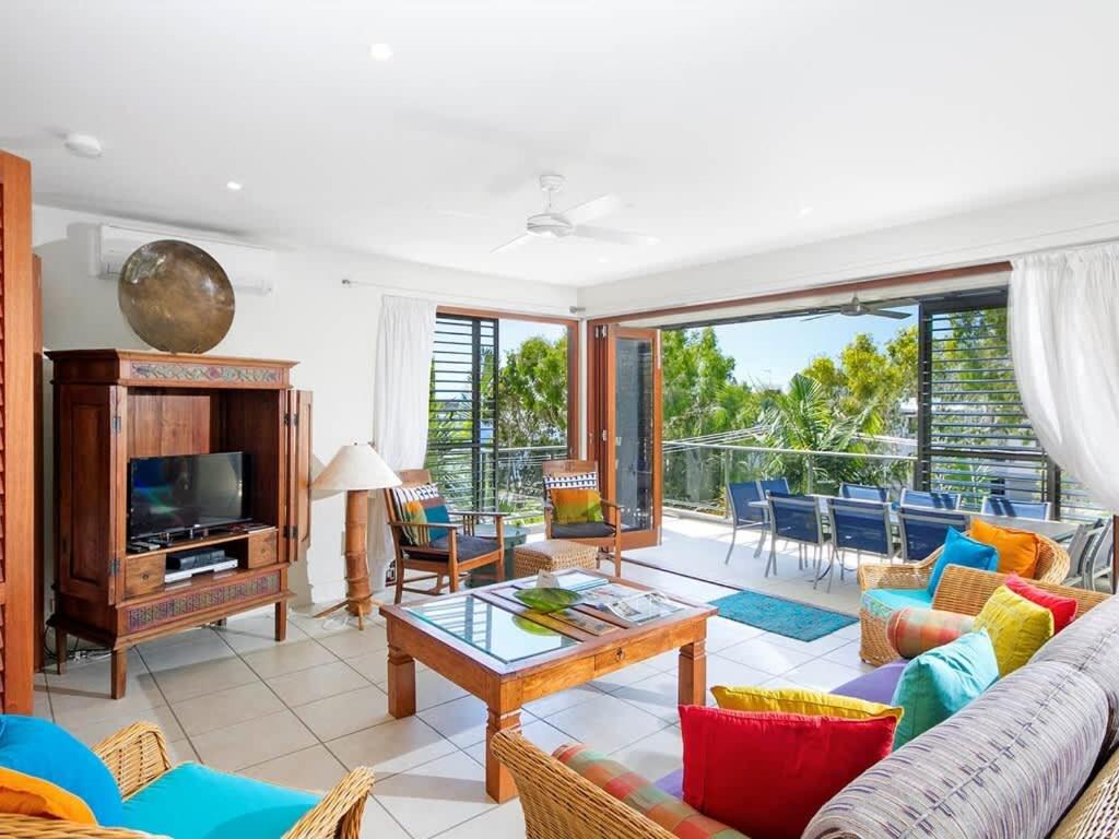 a living room with a couch and a tv at Noosa Dua 2 Balinese Retreat in Noosa Heads